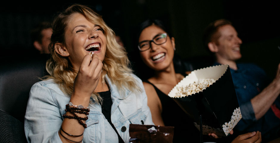 Personas disfrutando en el cine, representando los beneficios del método de ahorro 50/20/30.