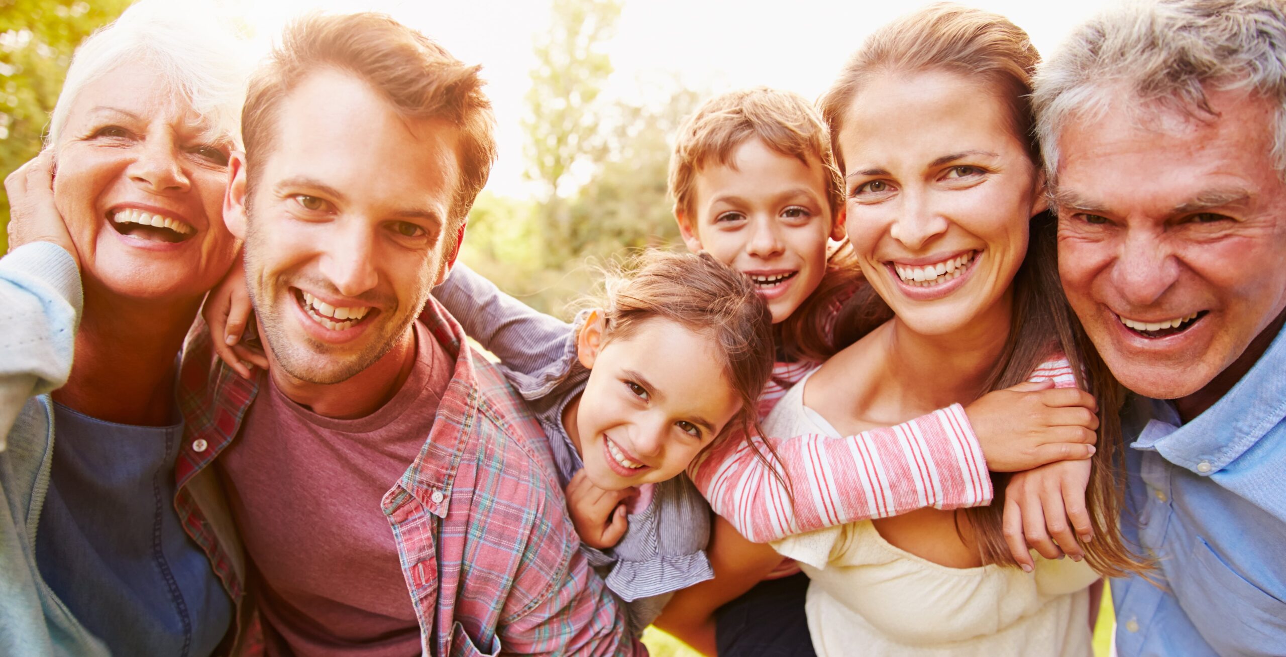 Família unida gaudint al´aire lliure representant el suport amb pensions familiars.