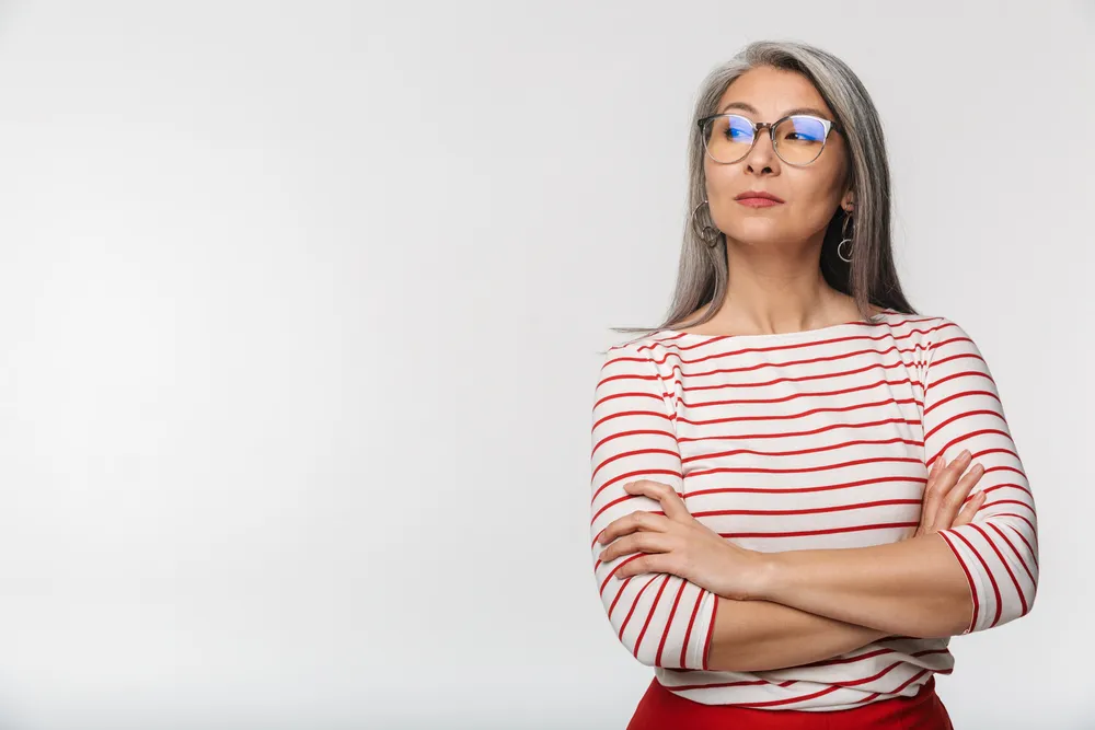 Mujer mayor con actitud decidida, representando la edad de jubilación según el año de nacimiento.