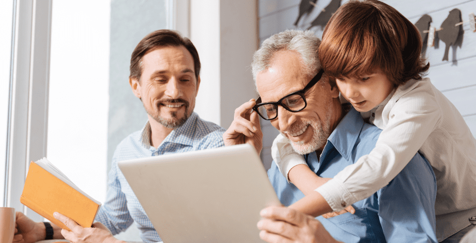 Tres generaciones revisando información sobre el Impuesto de Sucesiones y Donaciones en una tablet.
