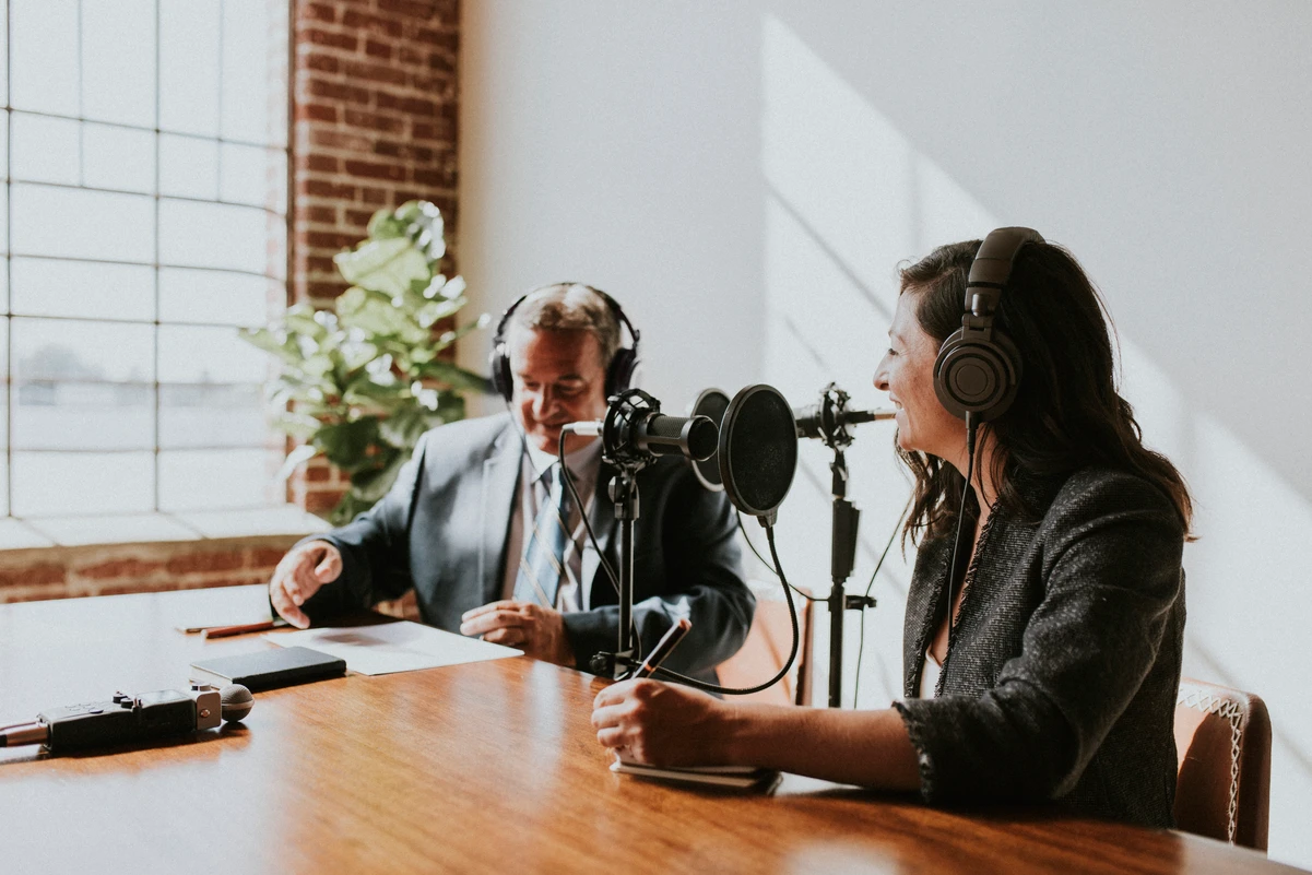 Dos personas grabando un podcast sobre finanzas personales, representando contenido para mejorar la economía personal.