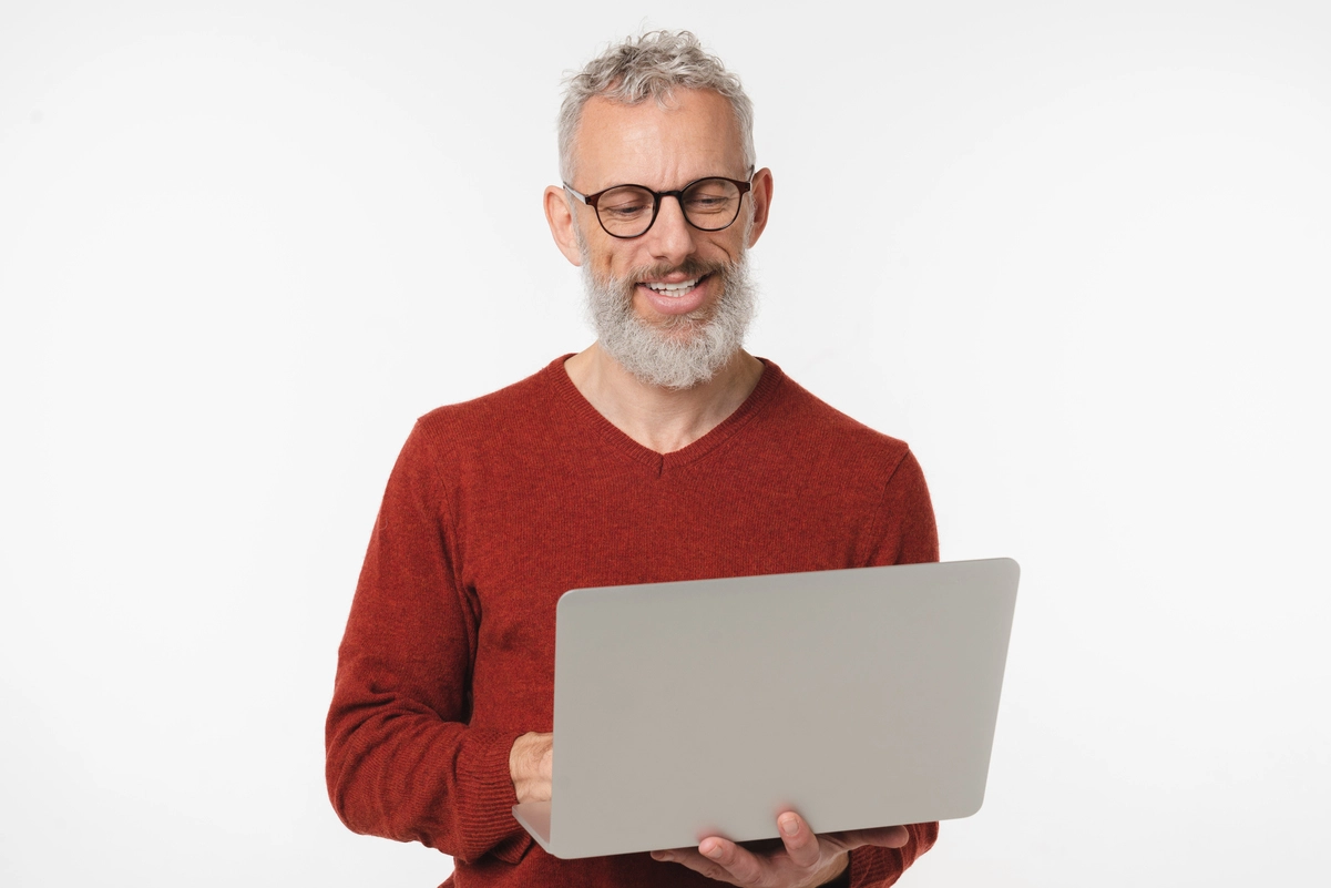 Hombre sonriente utilizando su ordenador portátil para consultar su vida laboral.