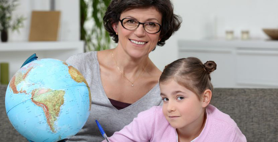 Mujer sonriente con gafas junto a una niña y un globo terráqueo, sobre jubilación de amas de casa.