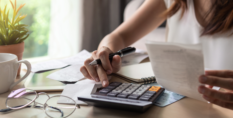 Dona usant calculadora i revisant rebuts per entendre bases imposable i liquidable.