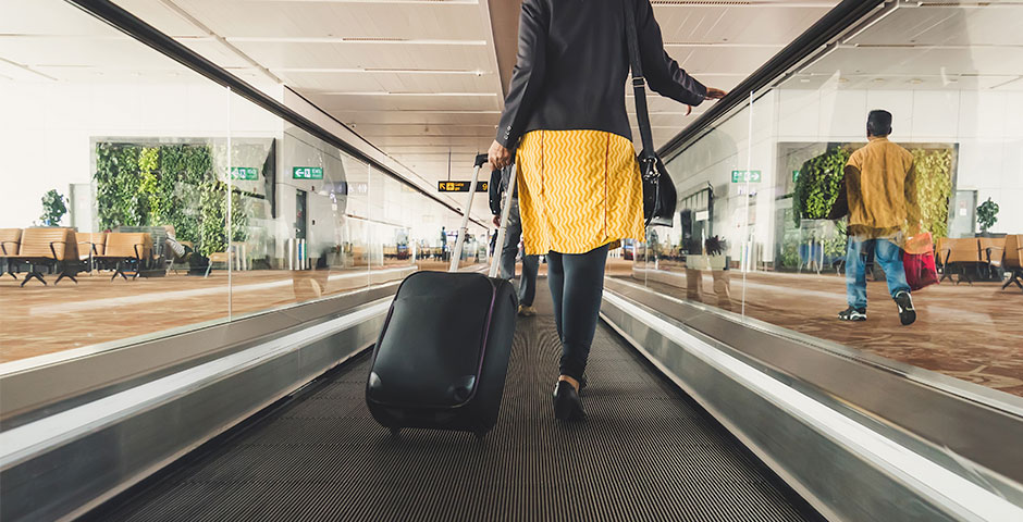 Persona caminando en aeropuerto con maleta, explorando opciones para cobrar el paro de golpe.