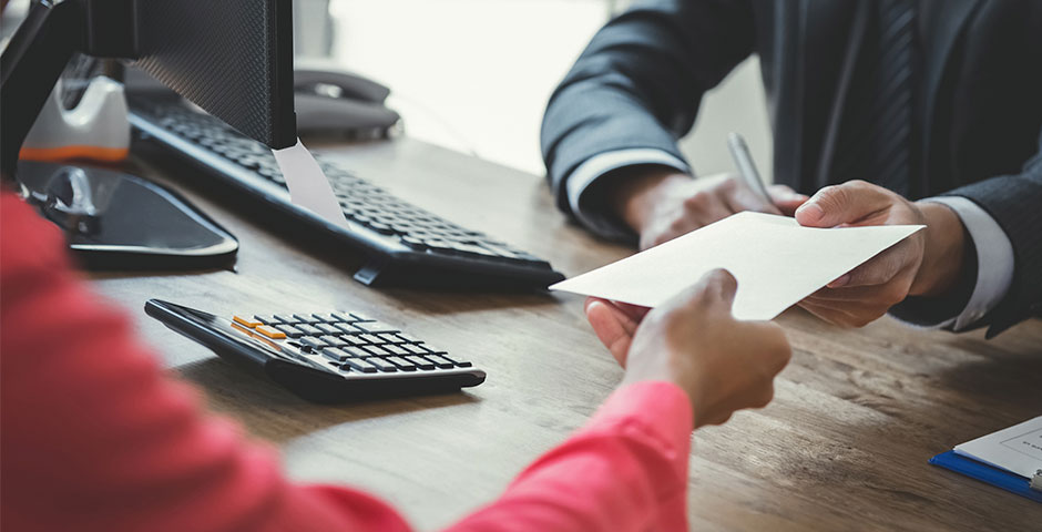 Persona lliurant document a oficina, representant el procés per cobrar l'atur.