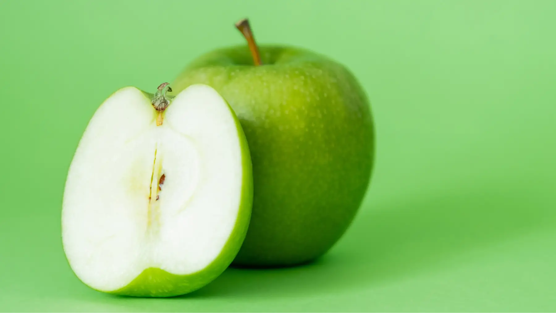 Manzana verde con monedas simbolizando cómo comer saludable y económico es posible.