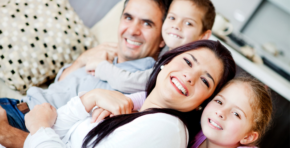 Família somrient a casa, símbol de com estalviem els espanyols per al futur.
