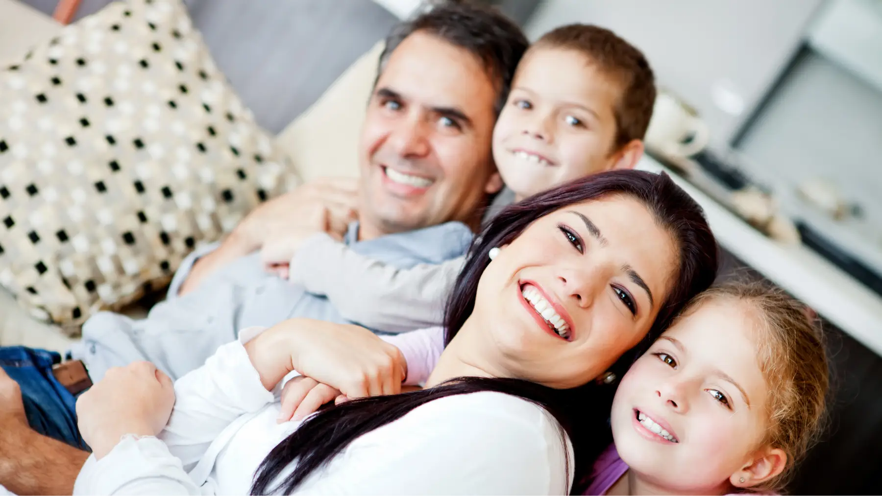 Família somrient a casa, símbol de com estalviem els espanyols per al futur.