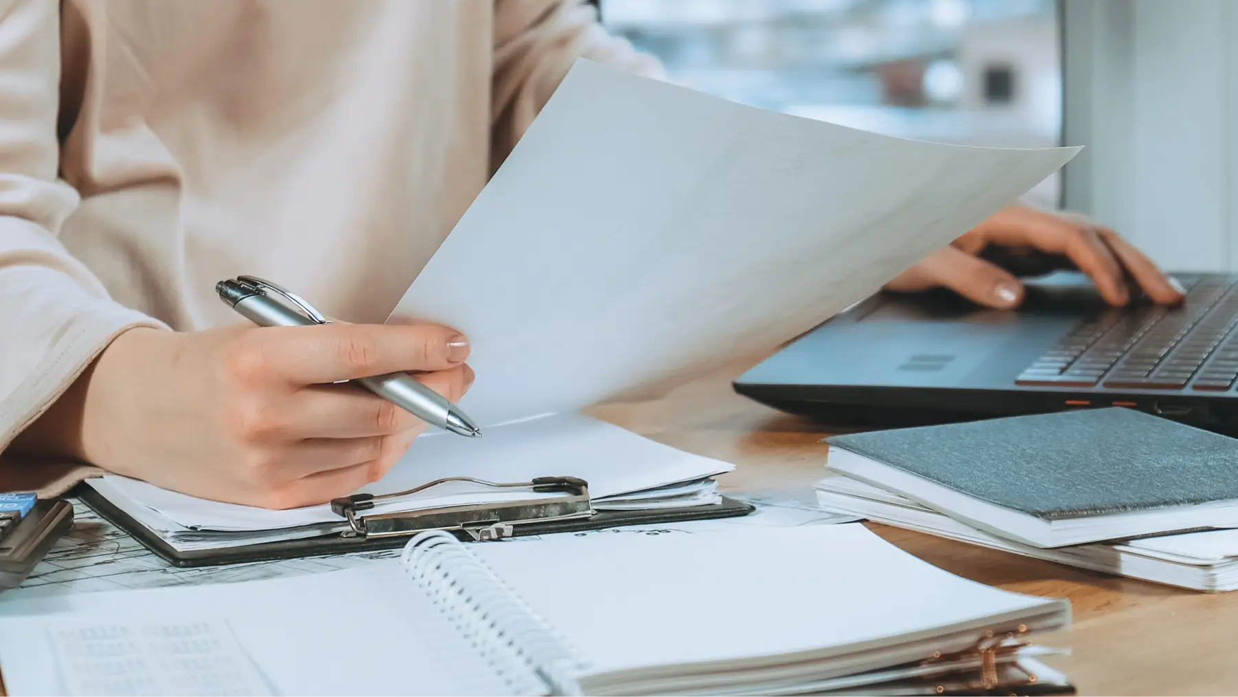 Persona revisant una llibreta bancària i documents, avaluant el millor pla d'estalvi.