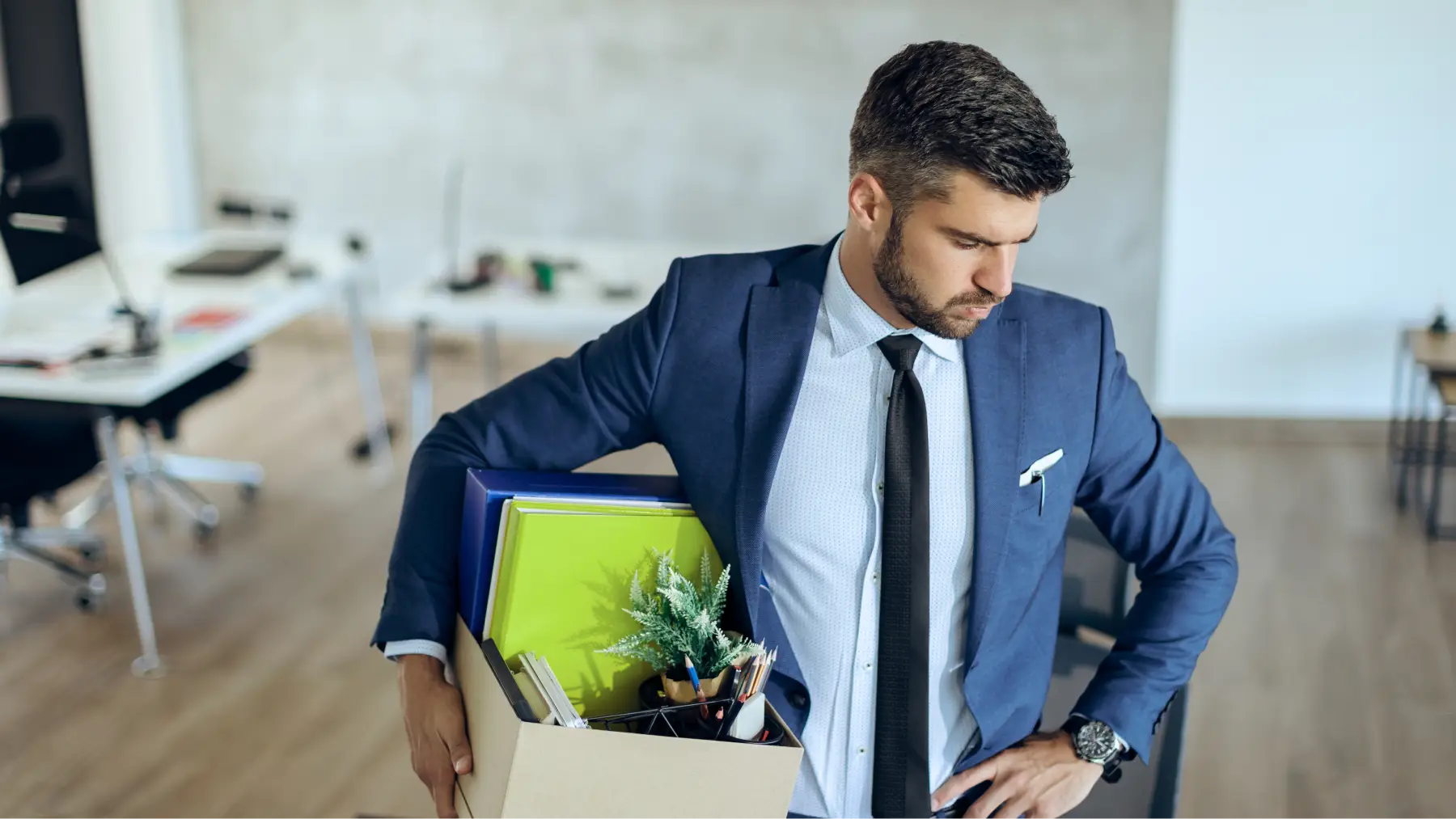 Hombre con traje y caja de oficina, simbolizando la diferencia entre finiquito e indemnización.
