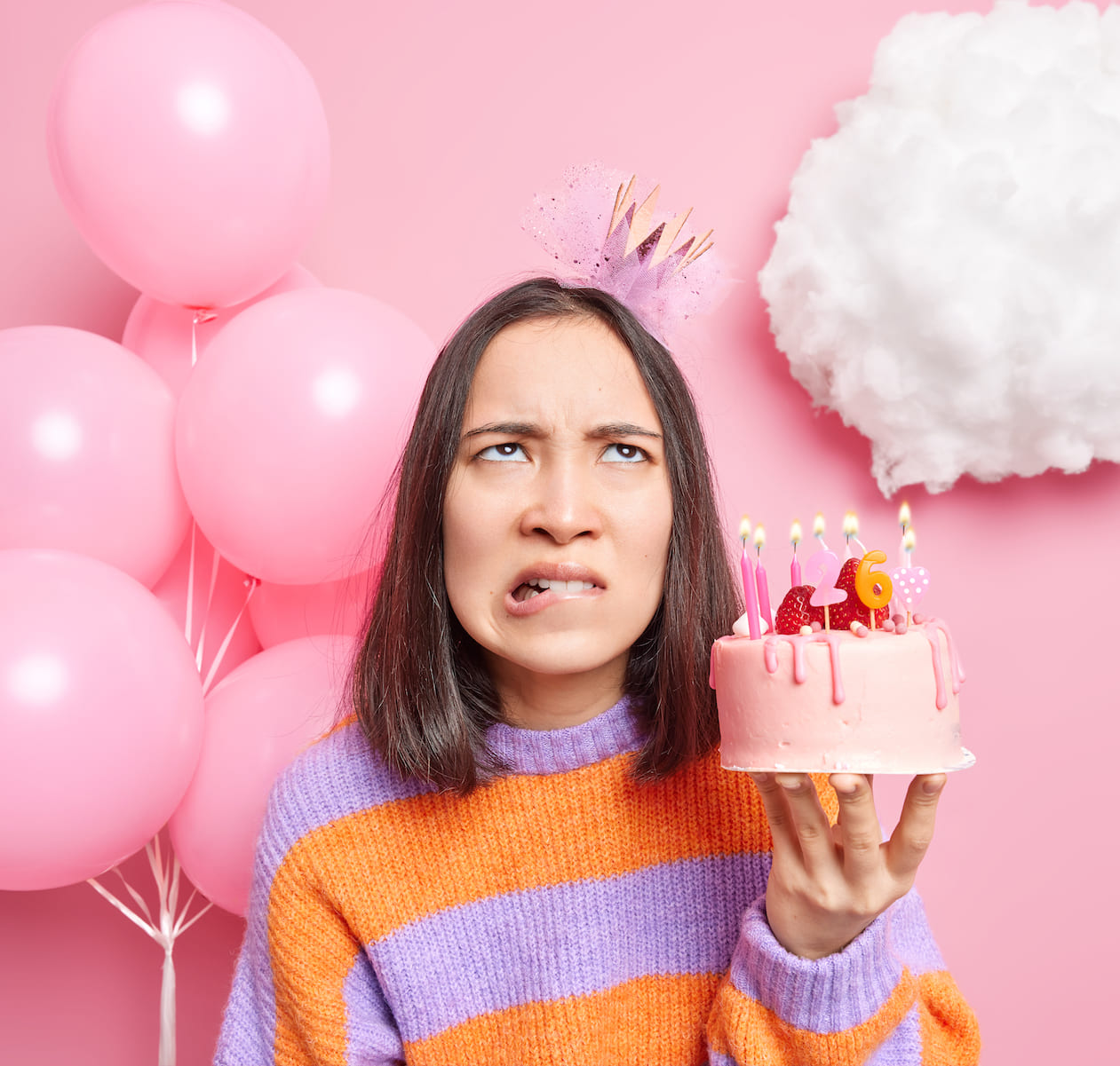 Mujer preocupada en su cumpleaños 26, cuestionando el inicio del envejecimiento.