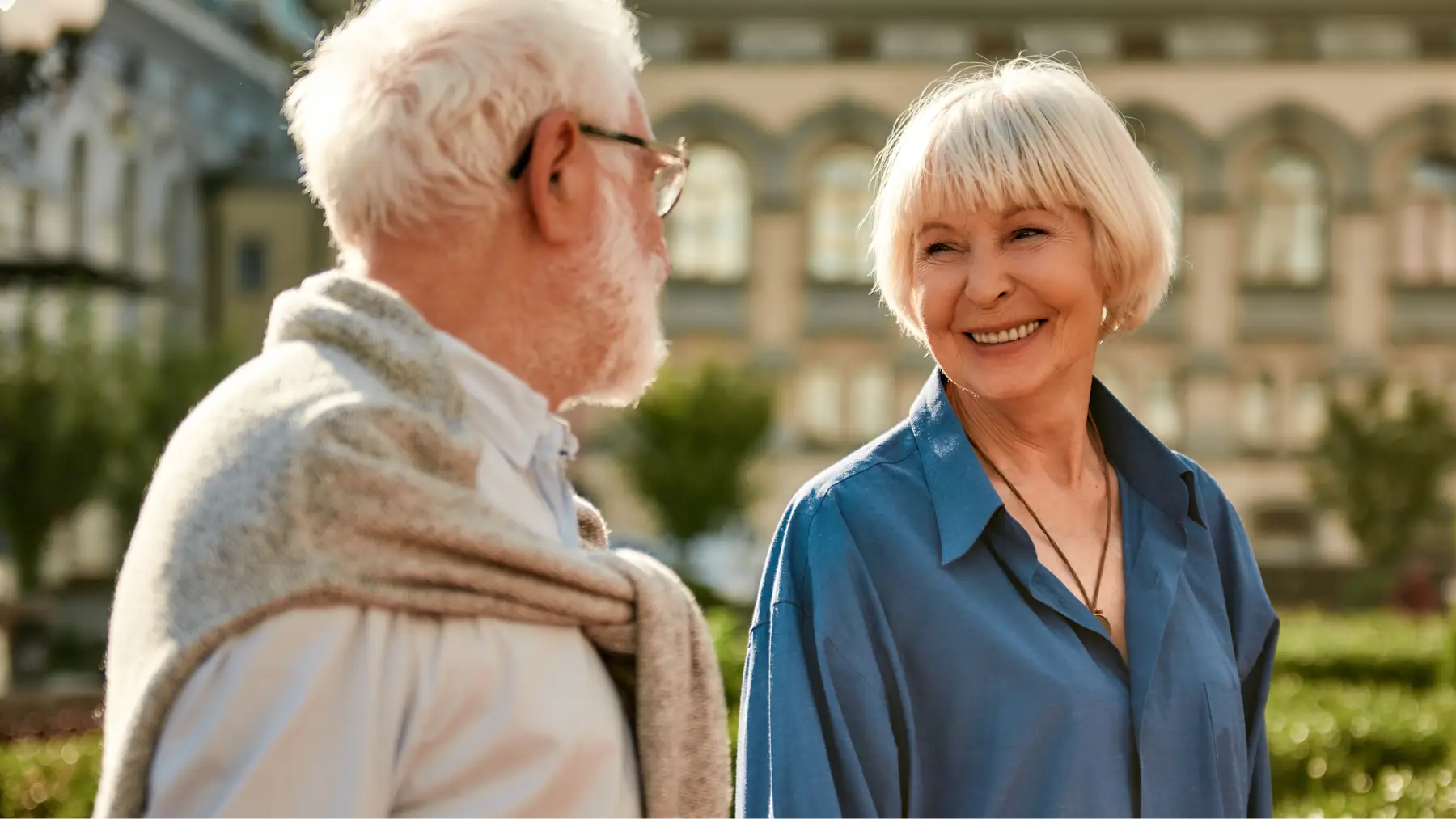 Pareja de jubilados sonrientes explorando el sistema de pensiones británico en su viaje.