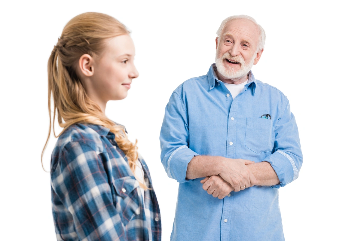 Jove i ancià conversant somrients, representant el concepte d'elderspeak o llenguatge adaptat per a grans.