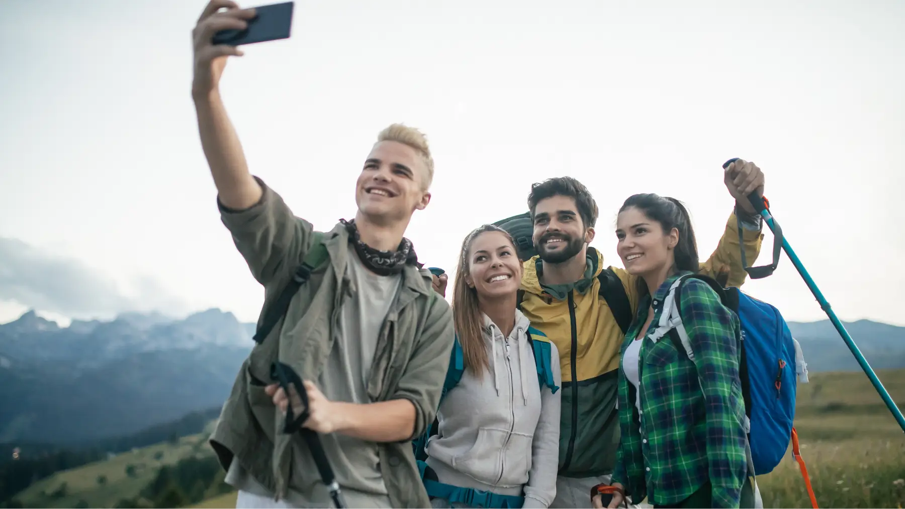 Amigos celebrando en la cima de una montaña, reforzando empatía y relaciones personales.