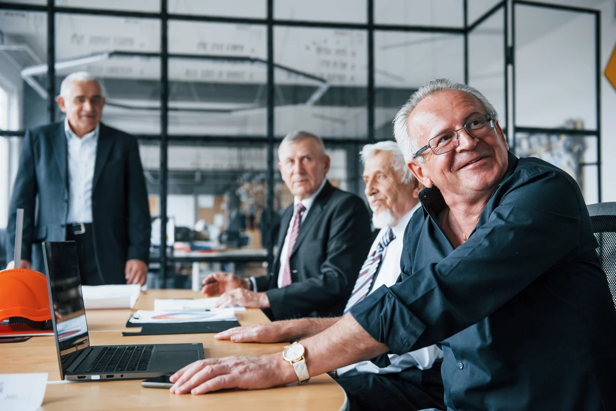 Hombres mayores trabajando juntos en una reunión sobre emprendimiento senior.