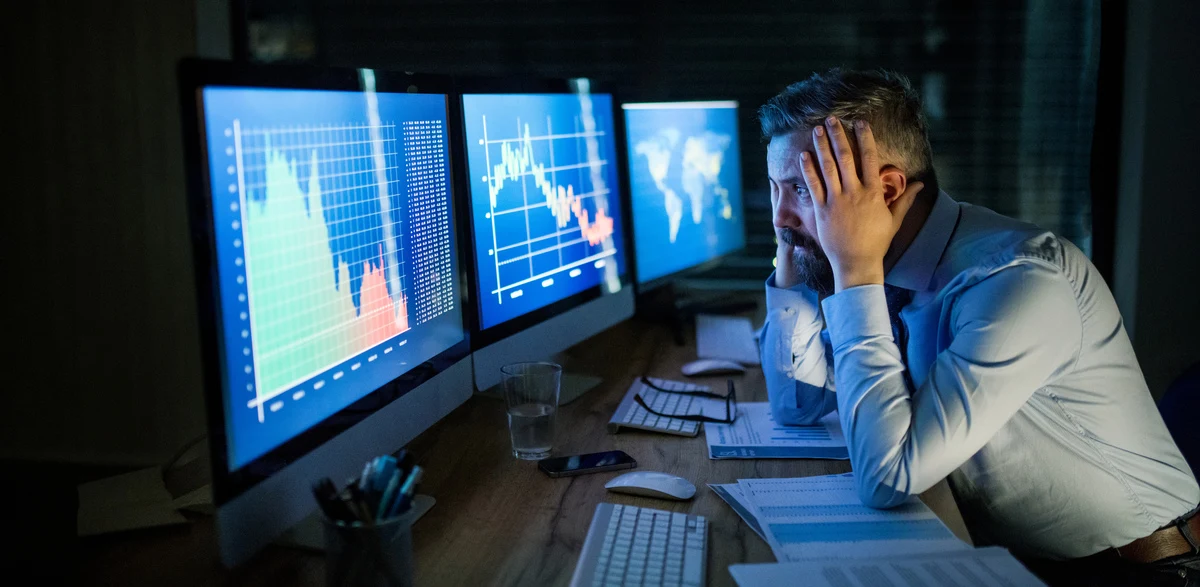 Inversor preocupado observando la caída de sus inversiones en el mercado financiero.