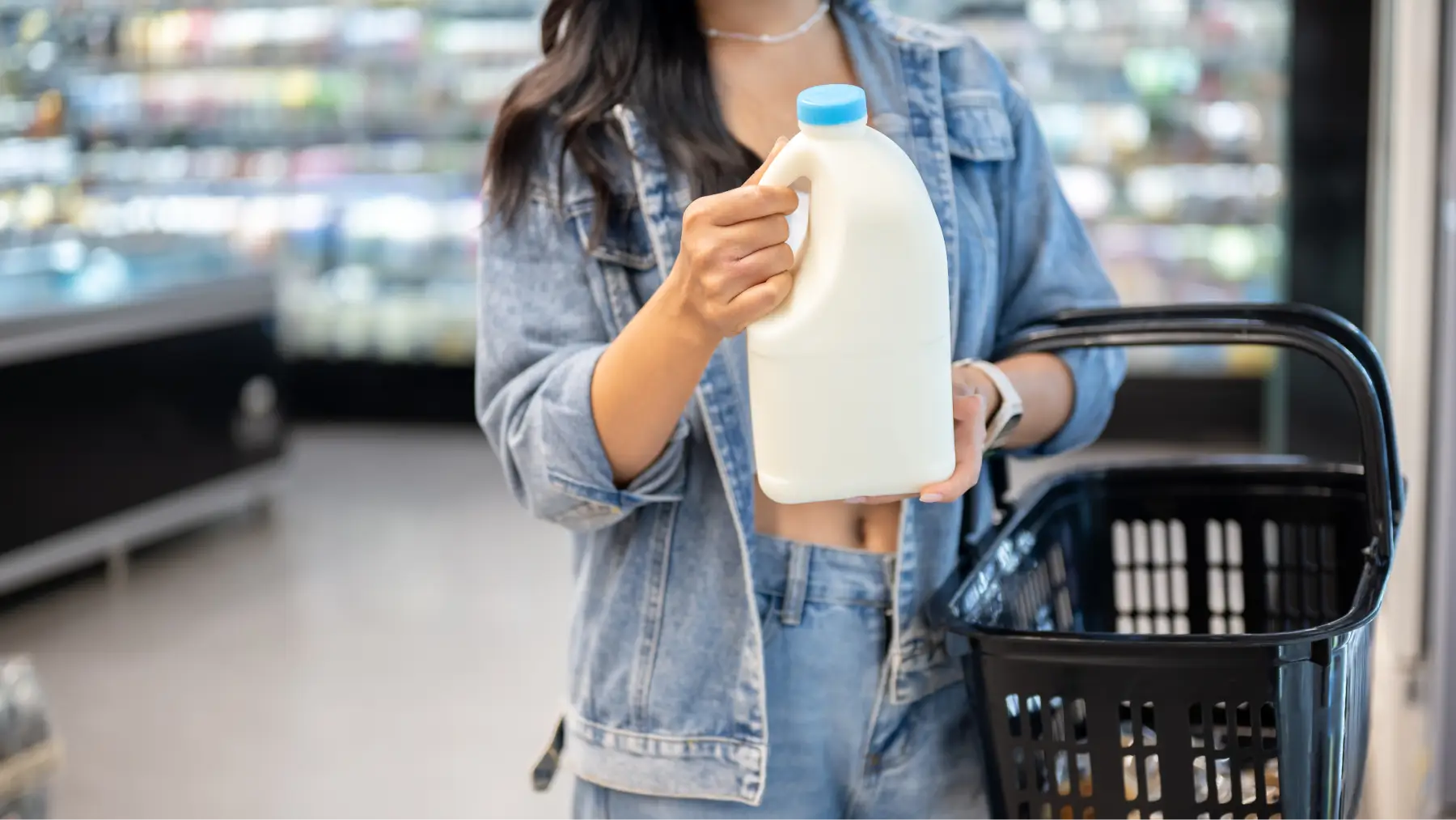 Persona sosteniendo un envase en el supermercado, analizando el nuevo etiquetado de alimentos y su impacto.
