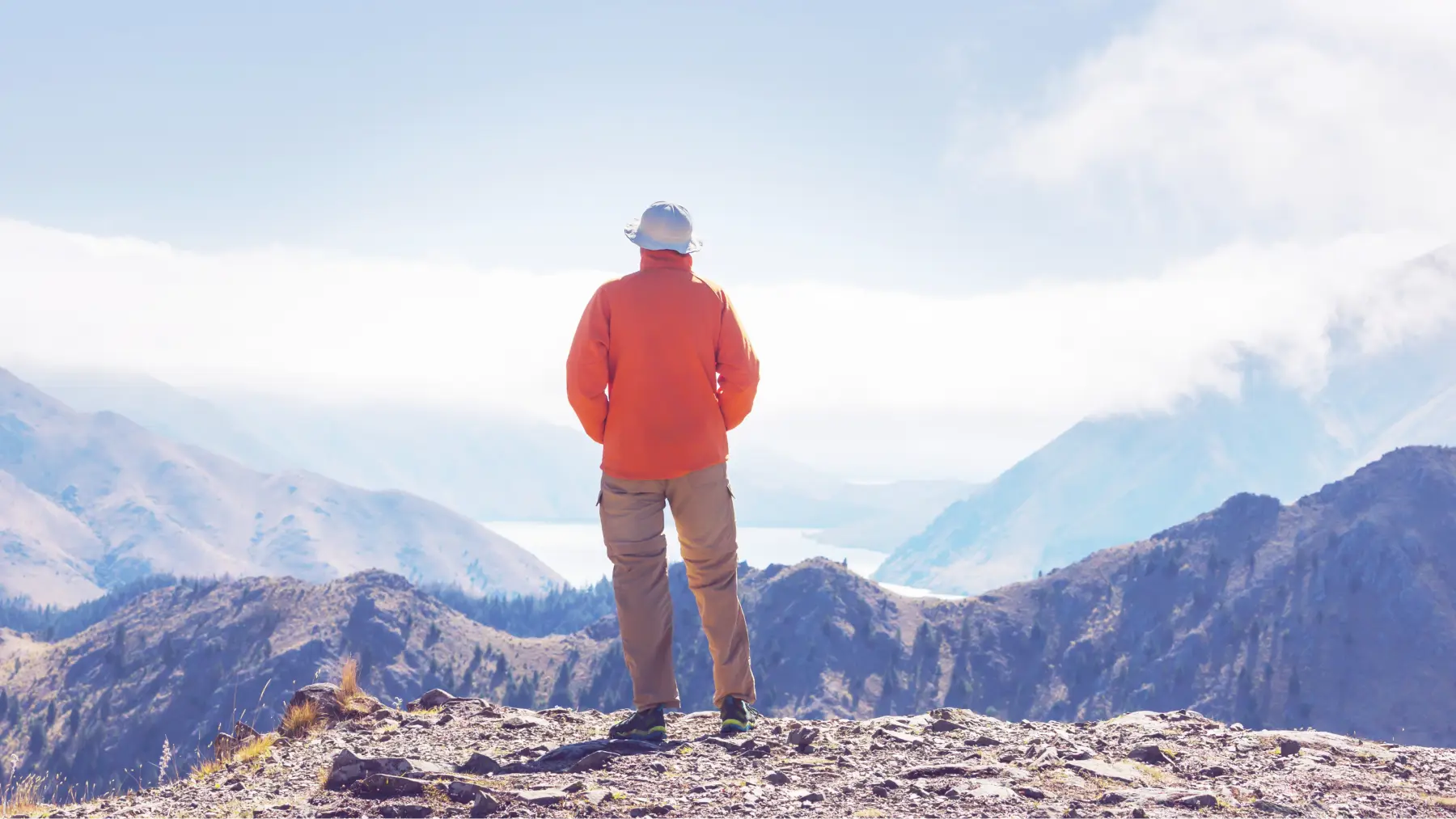 Hombre mayor en la cima de una montaña, simbolizando el júbilo de la libertad.