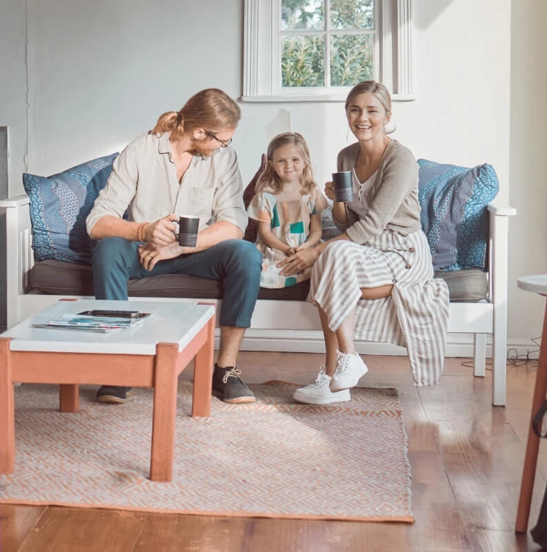 Familia sonriente disfrutando en casa mientras hablan sobre IVA en los seguros de vida.