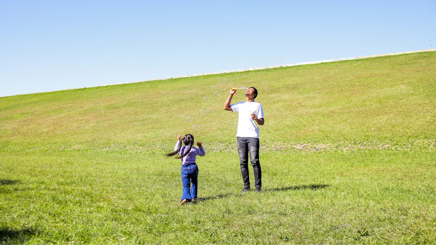Padre e hija volando una cometa en el campo, representando una jubilación activa.