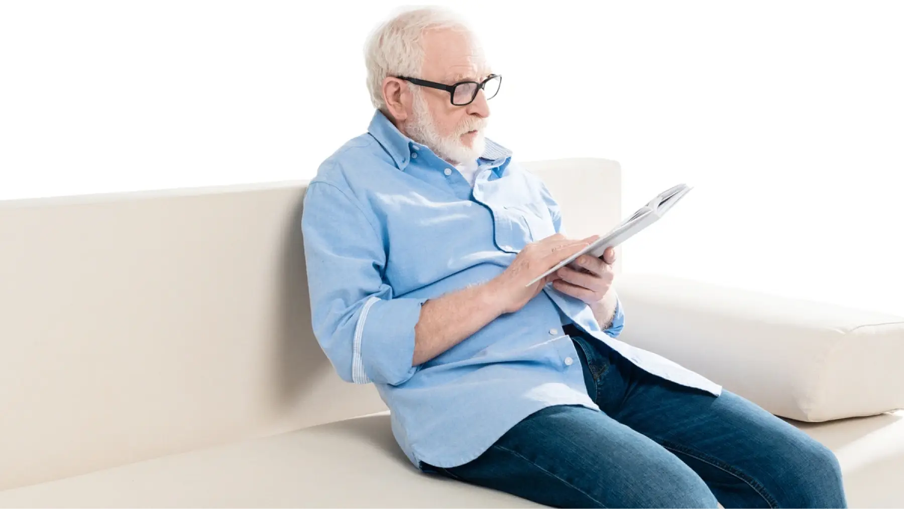 Hombre mayor en sofá leyendo un libro, representando recomendaciones esenciales sobre la jubilación.
