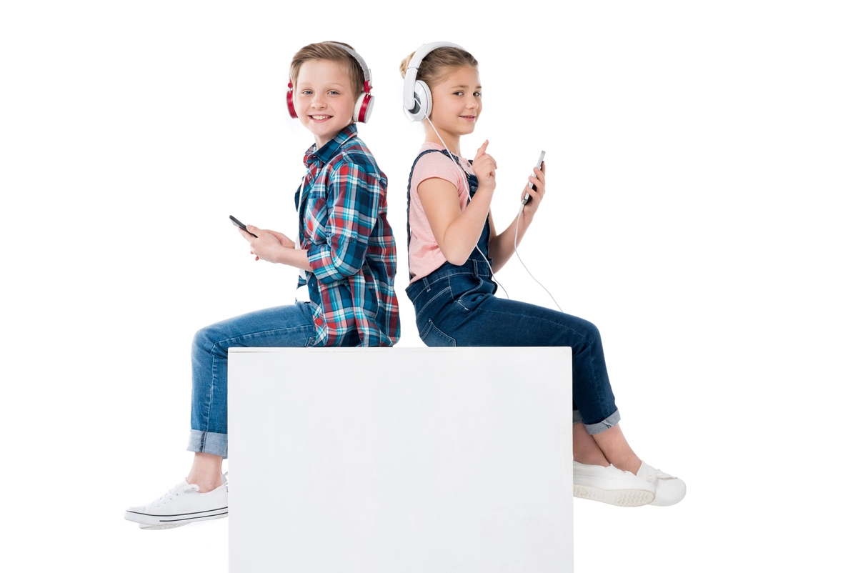 Niños con auriculares disfrutando de tecnología, simbolizando las ventajas de criar hijos con ayudas y permisos favorables.