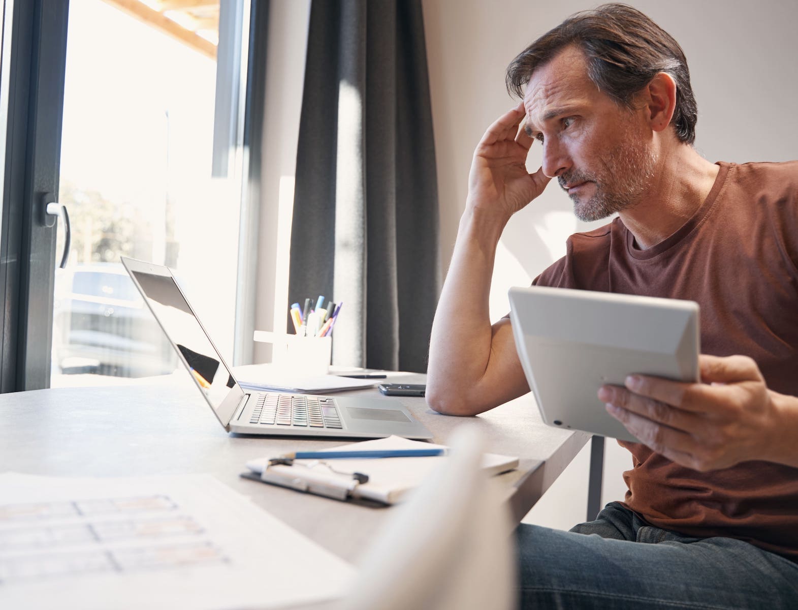 Hombre preocupado calcula el paro y revisa cuánto le corresponde por año trabajado.