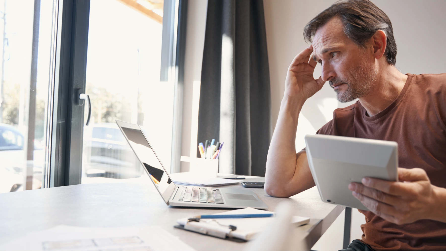 Hombre preocupado calcula el paro y revisa cuánto le corresponde por año trabajado.