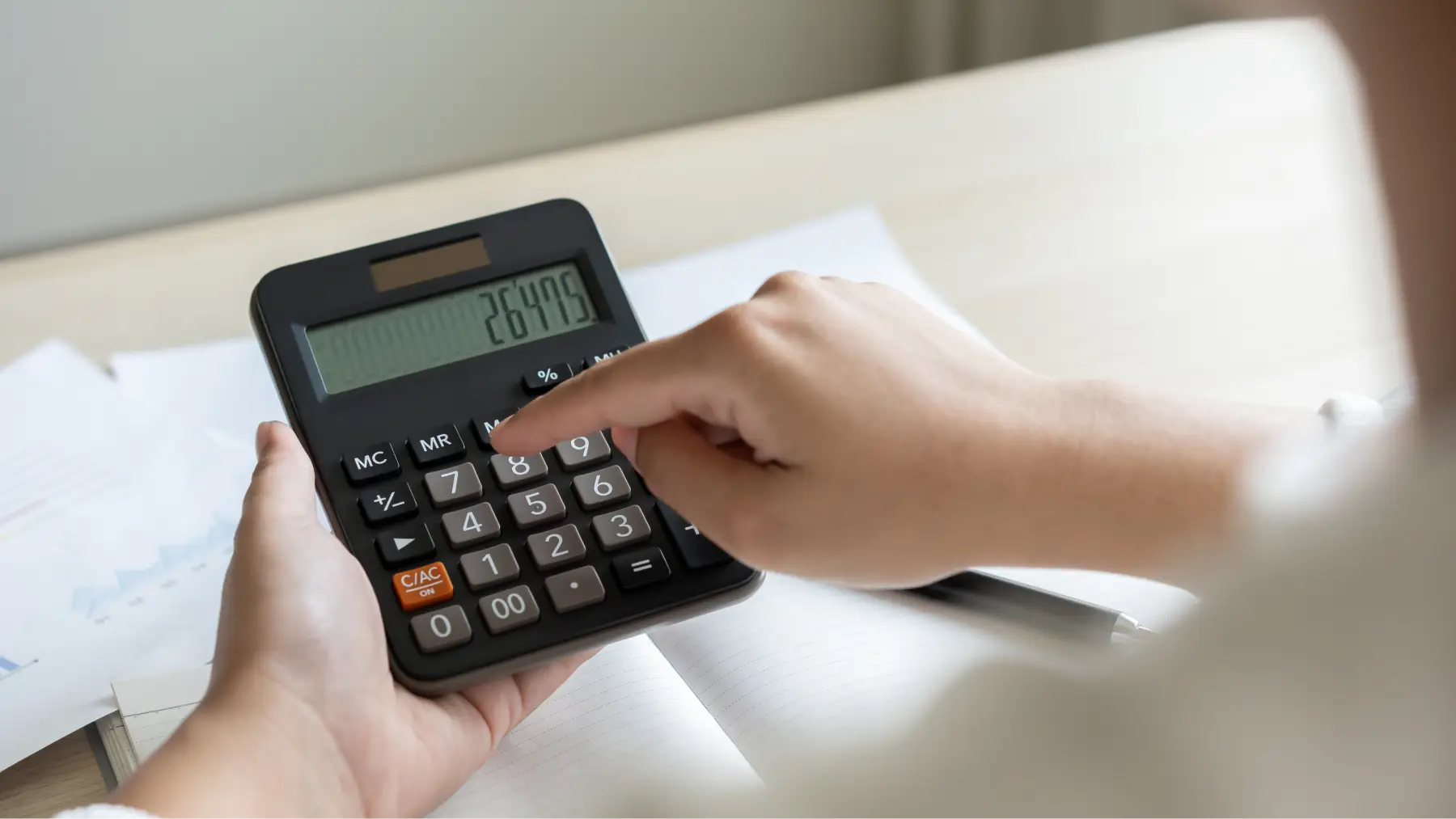  Persona utilitzant una calculadora, representant les novetats a la Declaració de la Renta. 