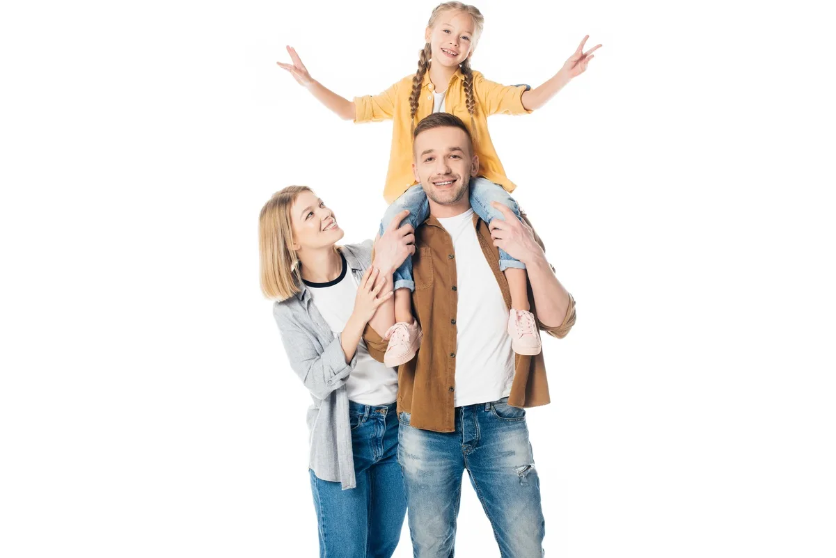 Padres sonrientes con hija sobre los hombros, simbolizando estabilidad y planificación financiera familiar.