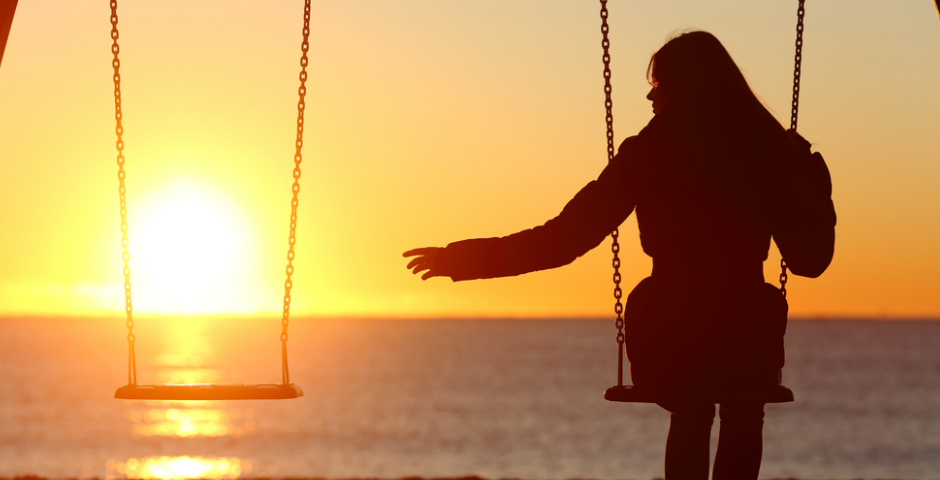 Persona sola en un columpio al atardecer reflexionando sobre la pensión de viudedad.