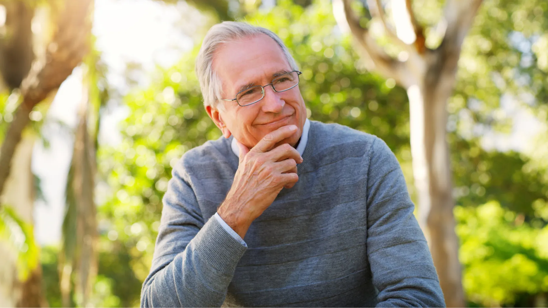 Hombre mayor sonriente mirando al horizonte, representando tranquilidad con pensión no contributiva.