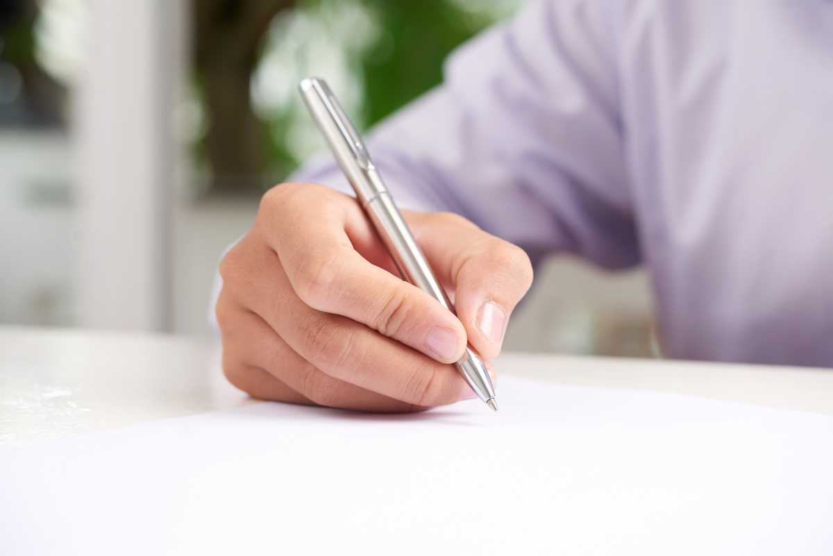 Persona amb alzheimer signant document assistida per professional