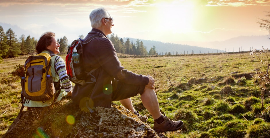 Pareja mayor disfrutando de un paisaje al atardecer mientras reflexionan sobre el futuro de las pensiones en España.