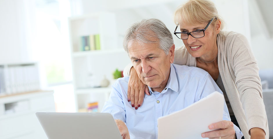 Pareja mayor revisando juntos documentos y su plan de pensiones en la declaración de la renta.