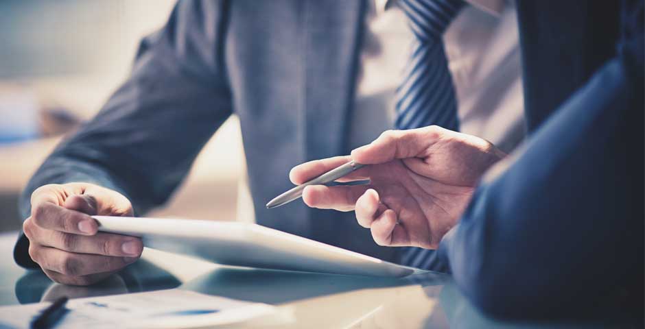 Dues persones revisant informació en una tauleta, il·lustrant les comissions de control en plans de pensions.