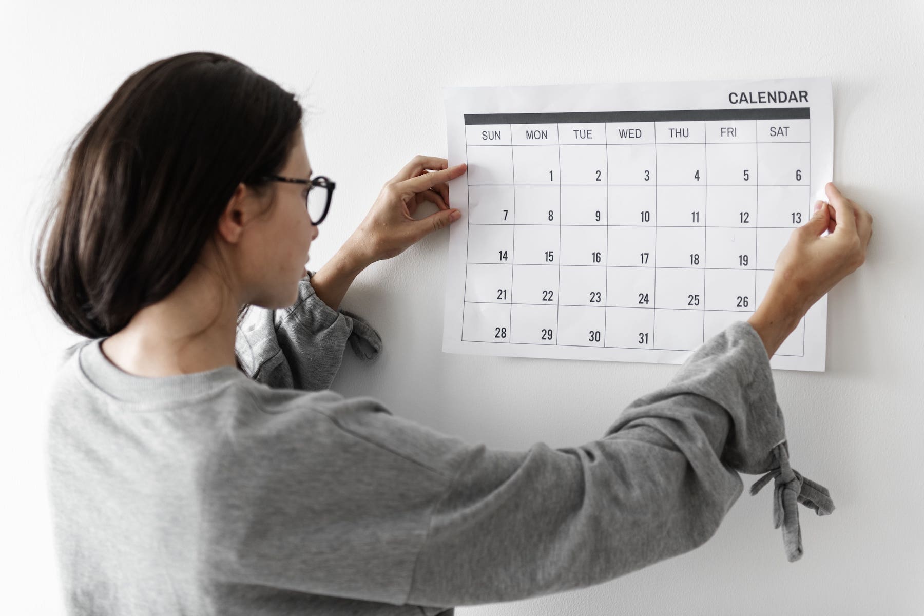 Dona ajustant un calendari simbolitzant el termini per reclamar una assegurança de vida.