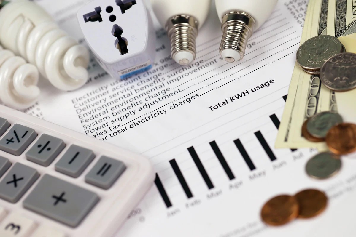 Factura de luz con bombillas y dinero encima, simbolizando el consumo eléctrico.