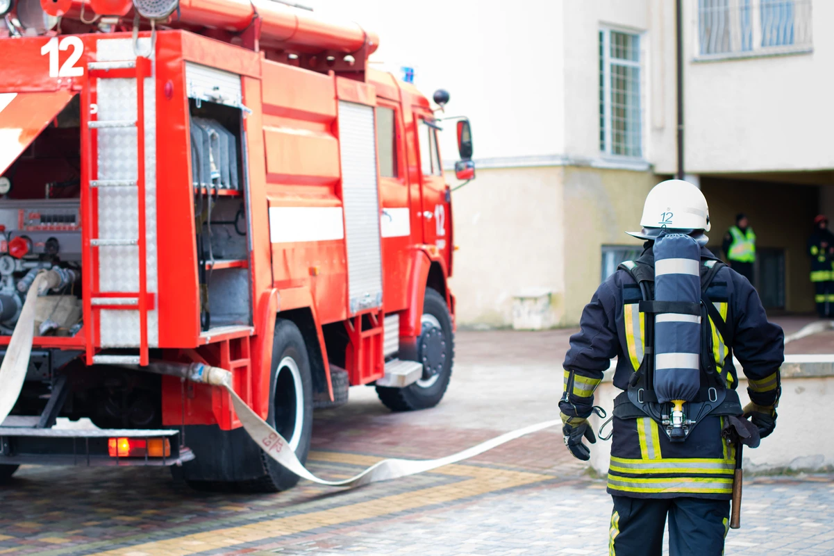 Bombero de espaldas junto a un camión, representando profesiones que permiten jubilarse anticipadamente.