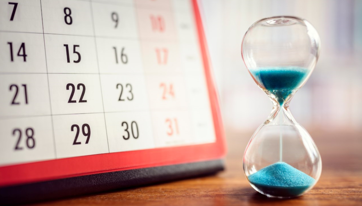 Calendari i rellotge de sorra blava indicant la data de cobrament de les pensions.