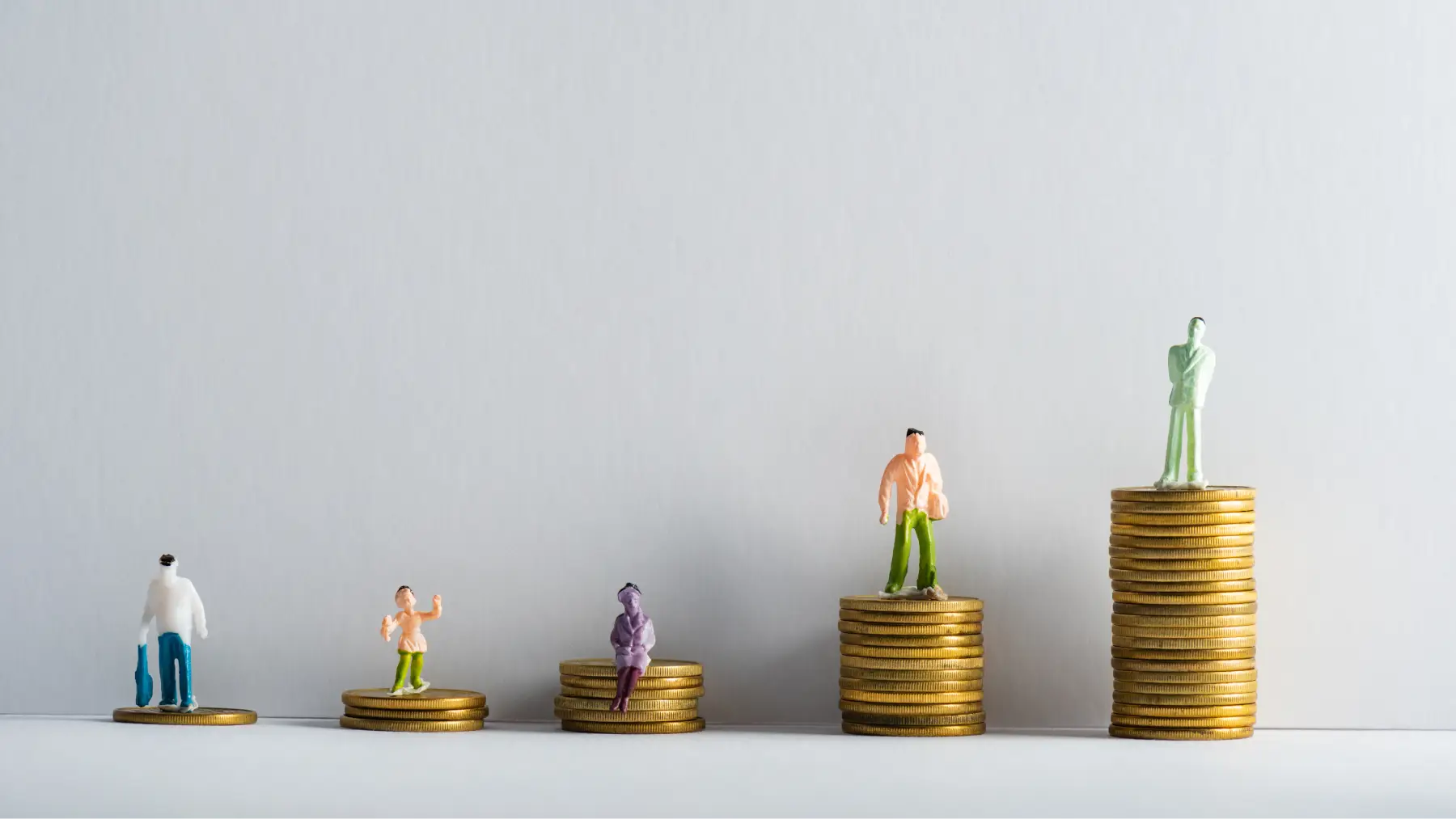 Figuras caminando sobre pilas de monedas, simbolizando seguros de vida para mayores de 50 años.