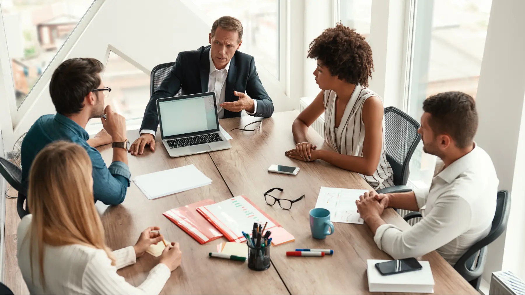 Grupo de empleados felices en una reunión de trabajo sobre seguros colectivos para empresas.