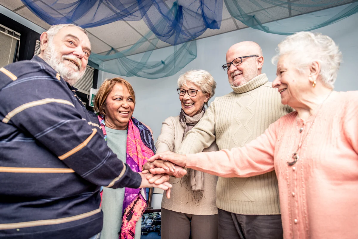 Personas mayores reunidas y sonrientes, simbolizando el senior living como alternativa a las residencias en España.