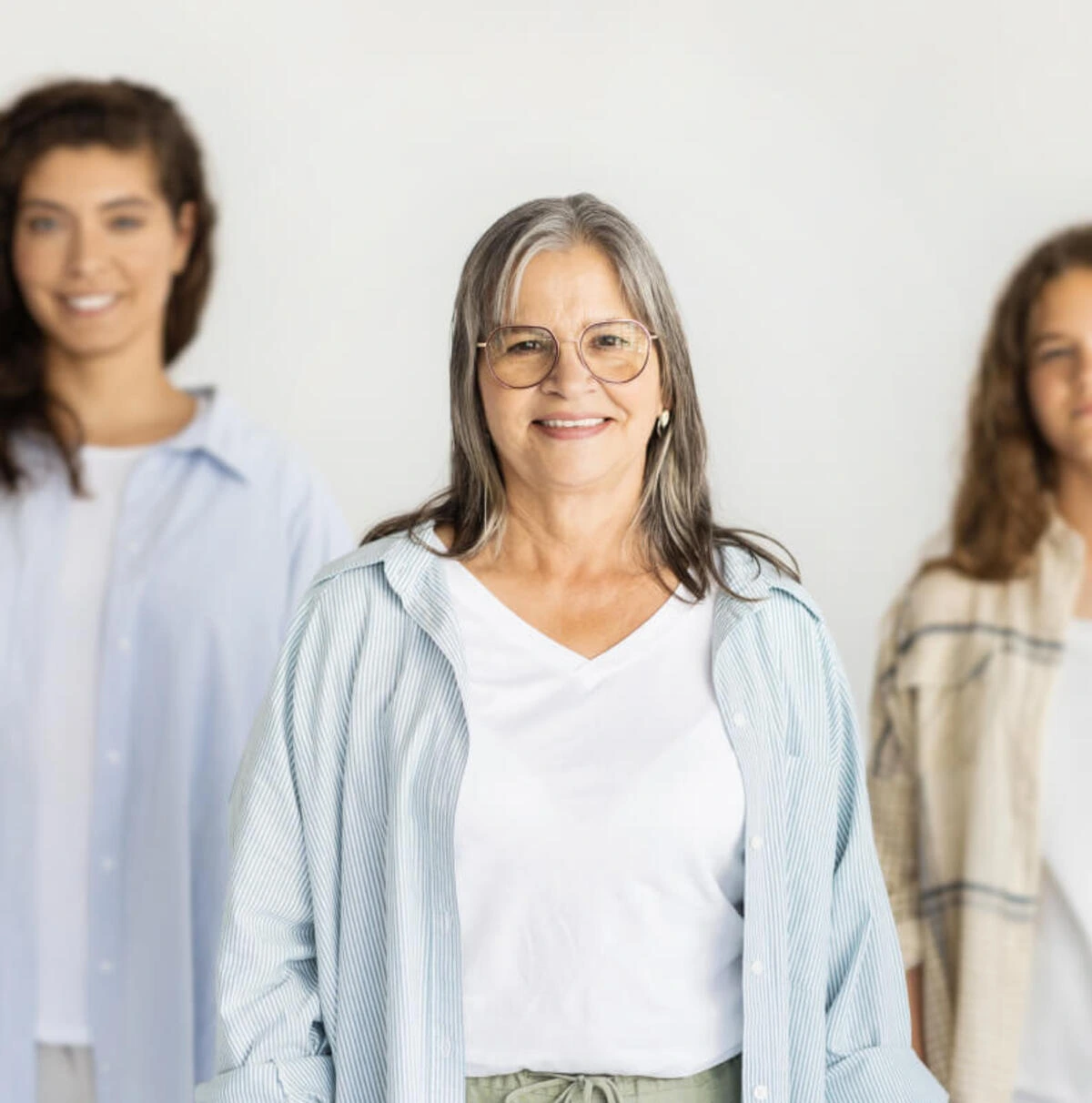 Grupo de tres personas sonriendo, mostrando diferentes edades y tipos de edadismo.