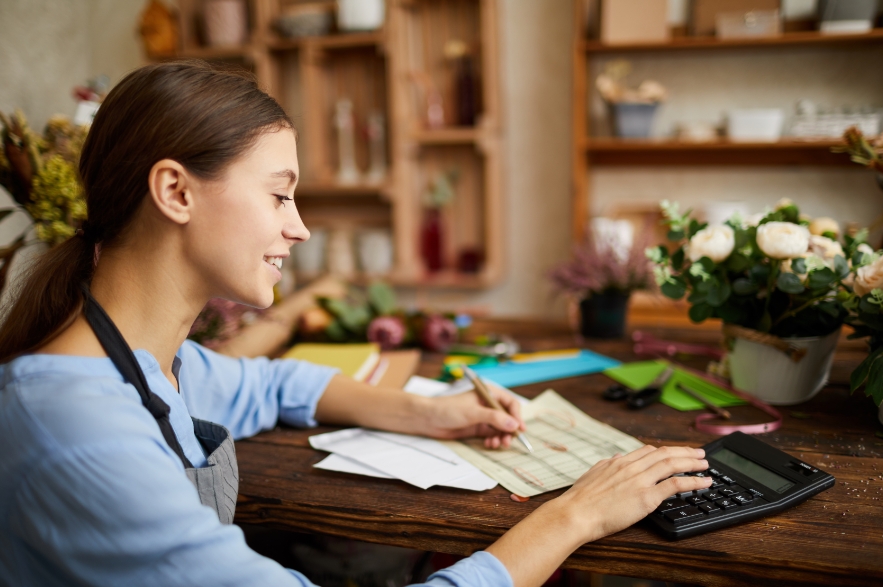 Mujer trabajando con documentos y calculadora, representando los distintos tramos del IRPF.