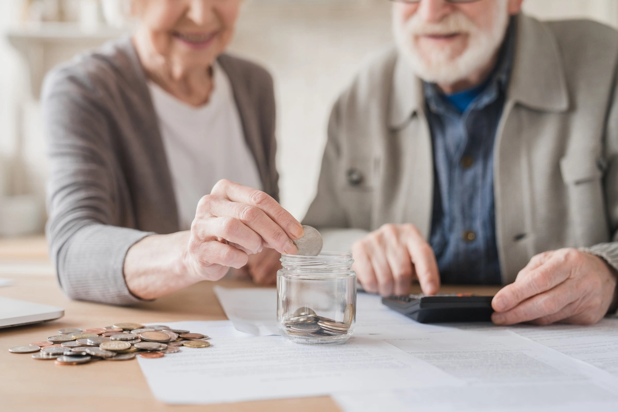 Una parella gran compta els seus estalvis i utilitza una calculadora per rescatar el pla de pensions.