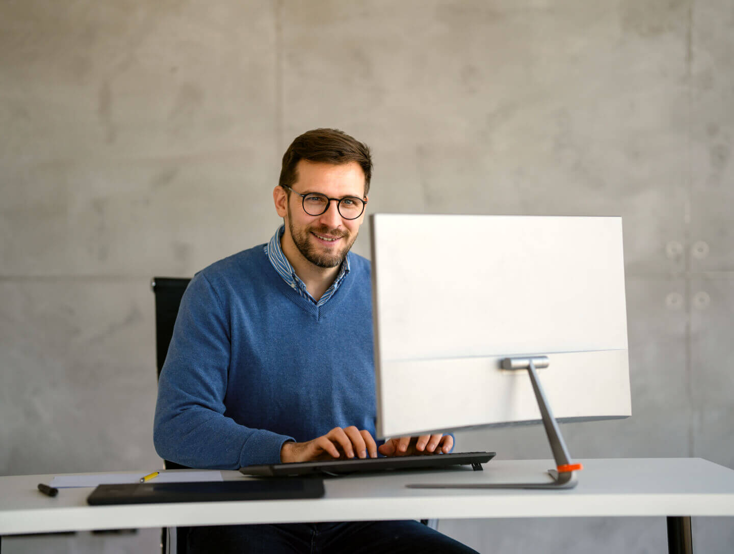 Self-employed person with glasses in office, associated with GeroCaixa pension plans.