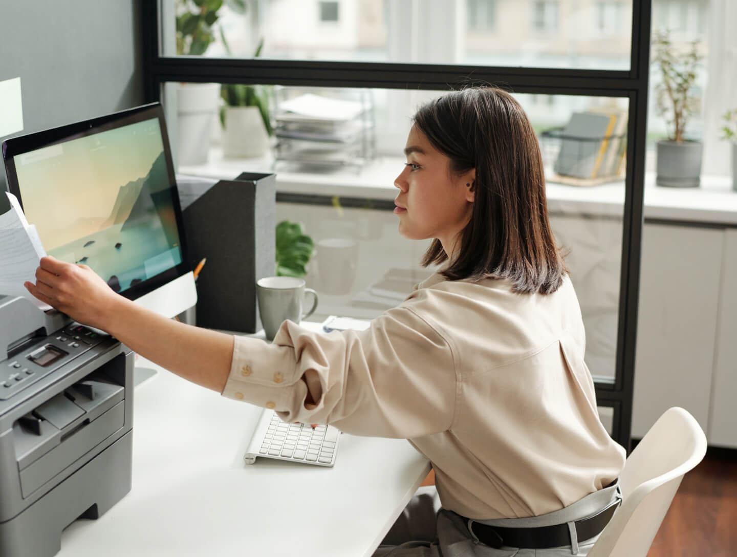 Self-employed woman in office printing documents, linked to Basque pension plans.